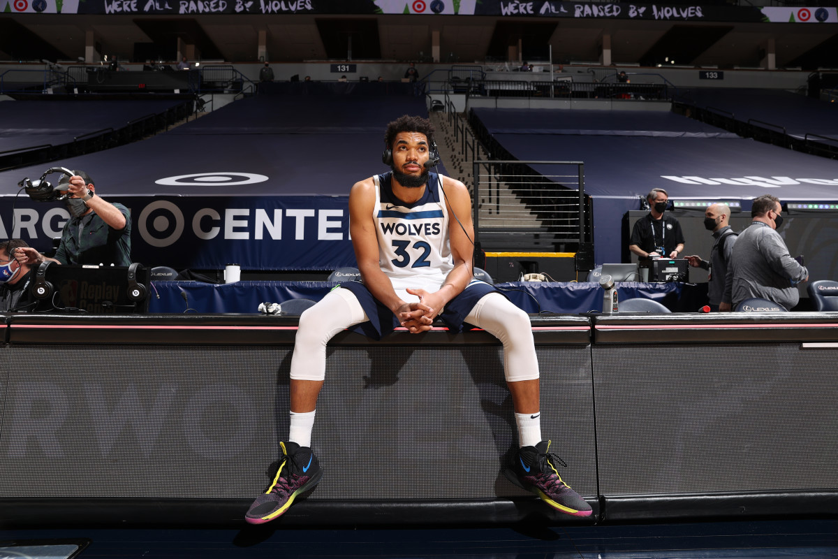 Karl-Anthony Towns sitting on the sideline with a headset on